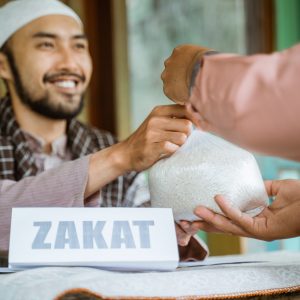 portrait of happy muslim man giving a rice as a food donation for zakat during eid mubarak at the mosque